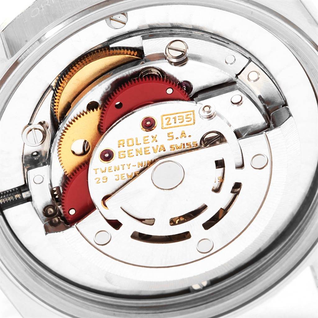 The image shows the internal movement mechanism of a Rolex Mid-Size 67480 Women's Stainless Steel Pink Dial 67480 Women's Stainless Steel Pink Dial model watch, highlighting gears and the rotor.