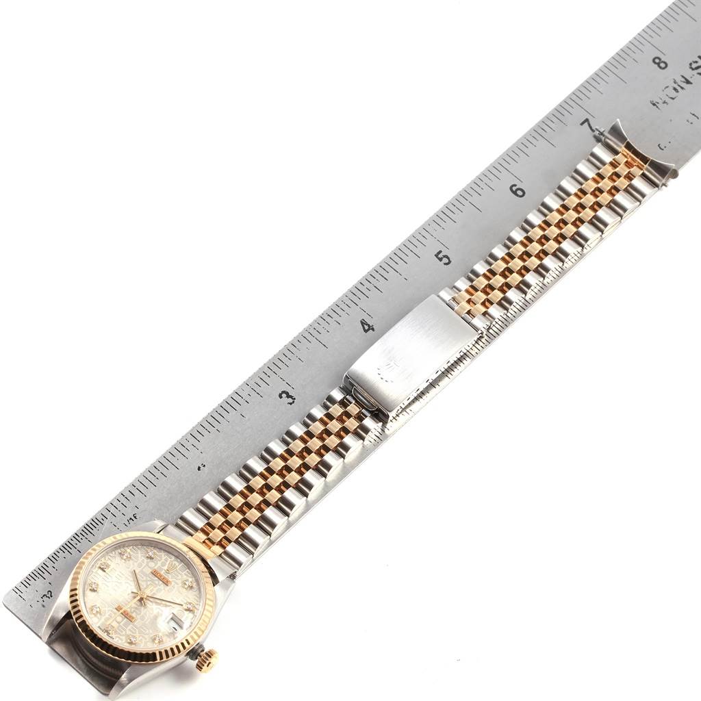 This image shows a Rolex Mid-Size 68273 Women's Steel and Gold (two tone) Silver Dial 68273 Women's Steel and Gold (two tone) Silver Dial watch from an overhead angle, displaying the face, bracelet, and clasp alongside a ruler.