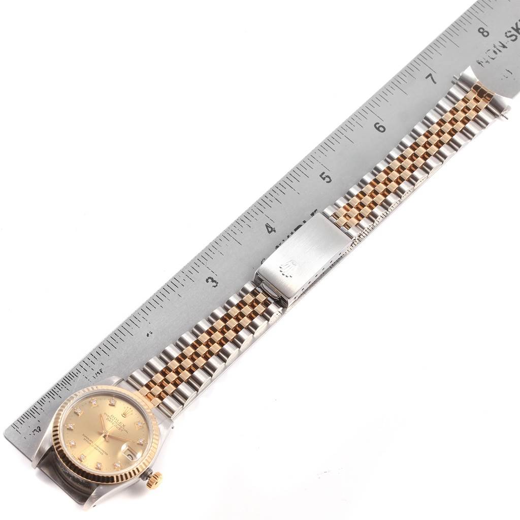 The image shows a top-down view of a Rolex Mid-Size 68273 Women's Steel and Gold (two tone) Champagne Dial 68273 Women's Steel and Gold (two tone) Champagne Dial watch with its face, case, and bracelet measured against a ruler.