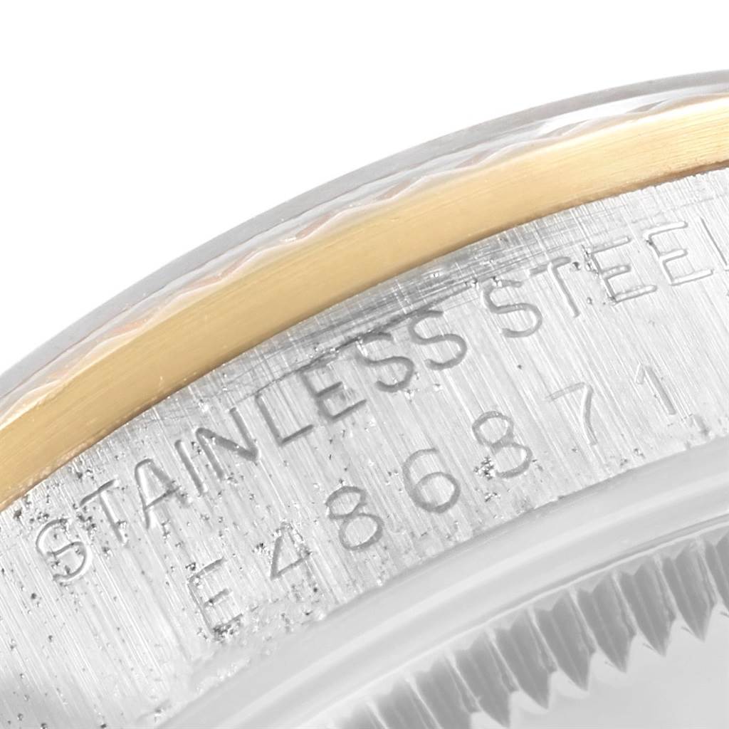 The image shows a close-up of the side case and edge of the bezel of a Mid-Size Rolex watch.