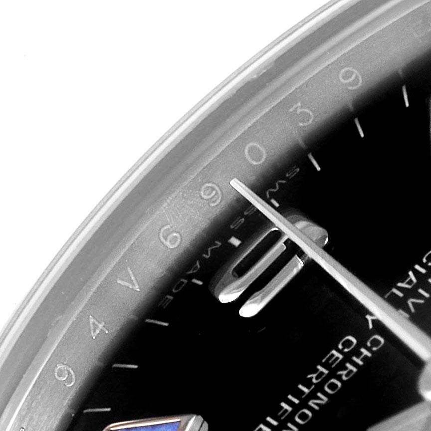 This close-up angle of the Rolex Mid-Size 177200 Women's Stainless Steel Black Dial 177200 Women's Stainless Steel Black Dial watch shows a portion of the dial, numerals, and one of the hands.