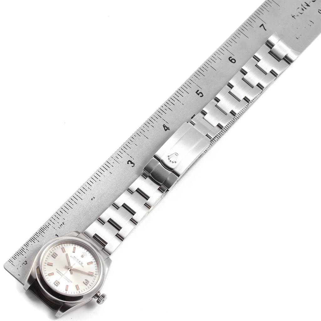 The image shows a Rolex Mid-Size 177200 Women's Stainless Steel Silver Dial 177200 Women's Stainless Steel Silver Dial watch laid flat alongside a ruler, displaying the watch face and stainless steel bracelet.