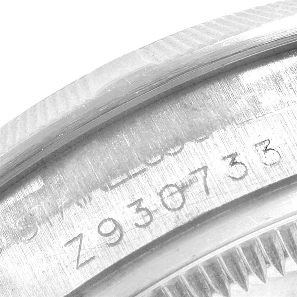 This image shows a close-up of the serial number and bezel edge of a Mid-Size Rolex watch.