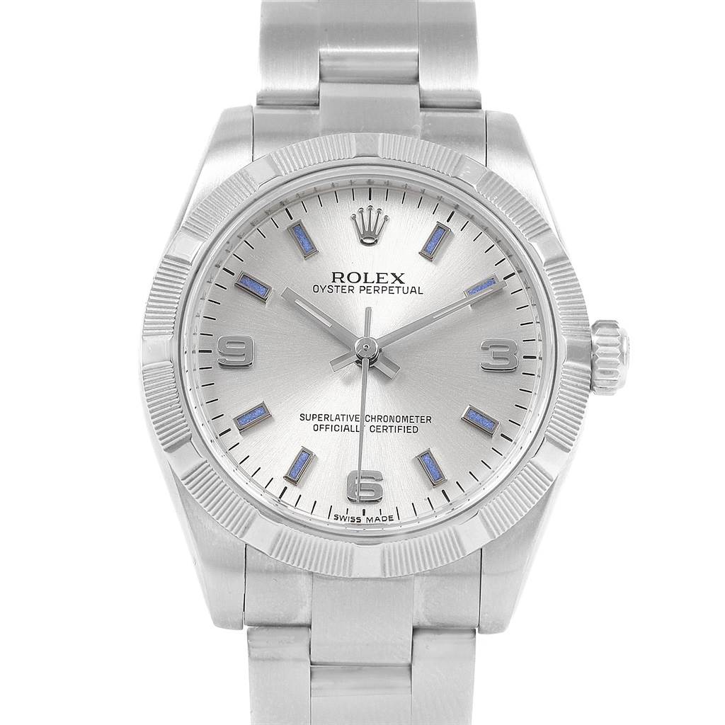 The image shows a front view of a Mid-Size Rolex Oyster Perpetual watch, displaying the dial, bezel, crown, and part of the bracelet.