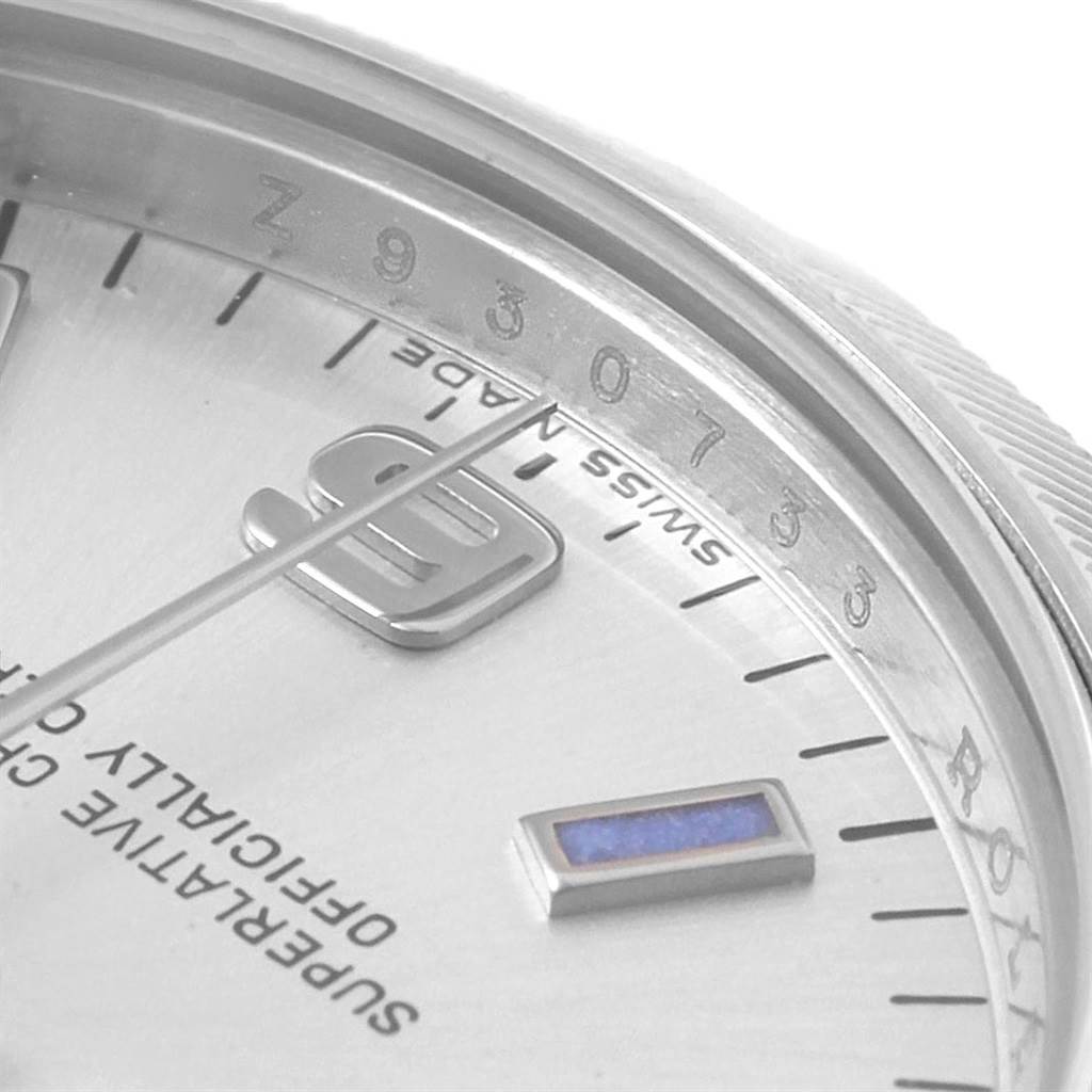 The image shows the close-up angle of the dial and bezel of a Mid-Size Rolex watch, highlighting the numeral at the 9 o'clock position and "Swiss Made" text.