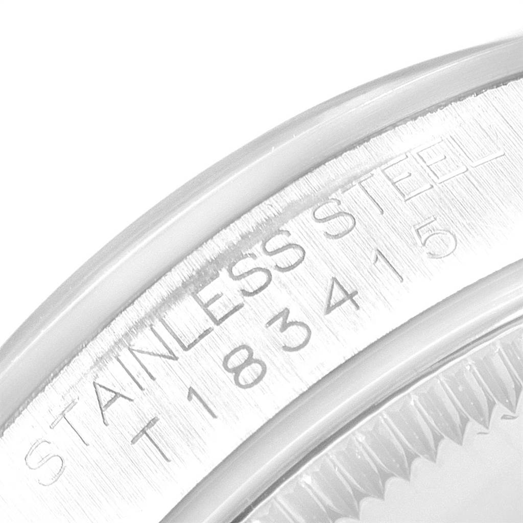 This image shows a close-up of the engraved case back of a Mid-Size Rolex watch, focusing on the "STAINLESS STEEL" text and serial number.