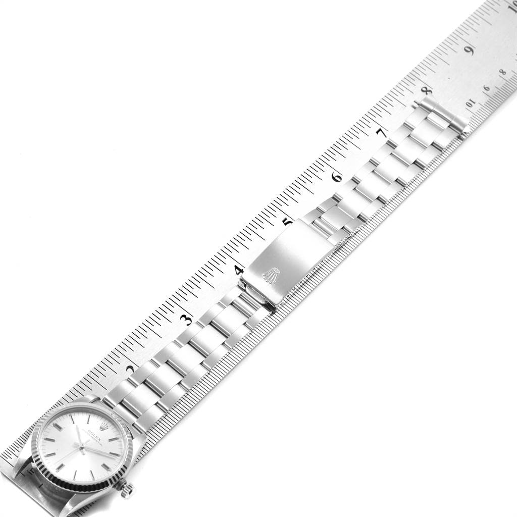 This image shows a top view of a Rolex Mid-Size 67514 Women's Stainless Steel Silver Dial 67514 Women's Stainless Steel Silver Dial watch, showcasing the watch face, bracelet, clasp, and a ruler for scale.