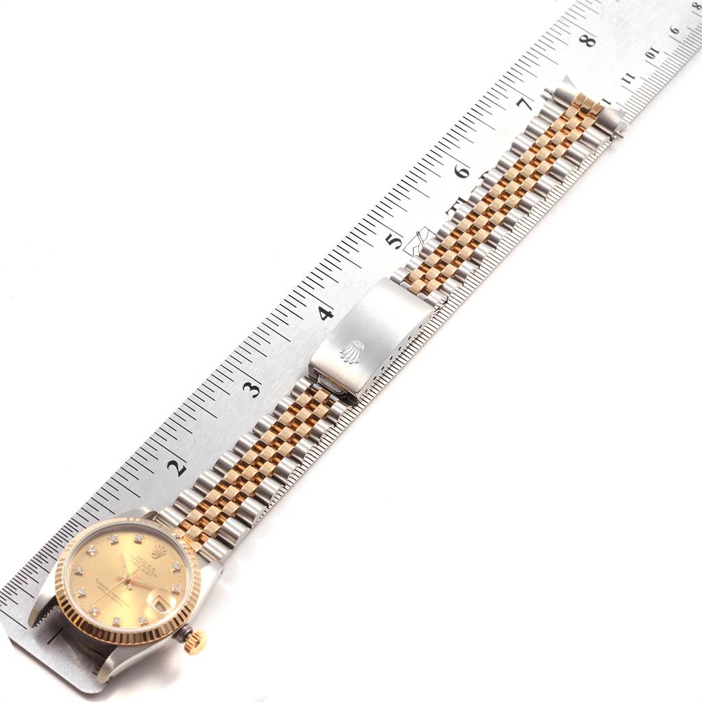 The image shows a Rolex Mid-Size 68273 Women's Steel and Gold (two tone) Champagne Dial 68273 Women's Steel and Gold (two tone) Champagne Dial watch laid flat next to a ruler, displaying its face, bracelet, and clasp.