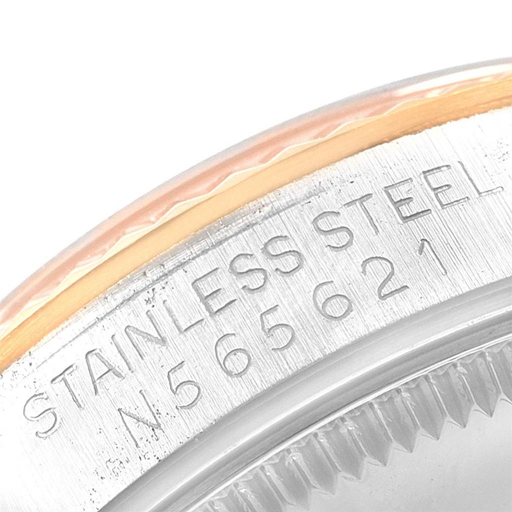 This close-up image of a Mid-Size Rolex watch shows the edge of the bezel and the engraved stainless steel serial number.