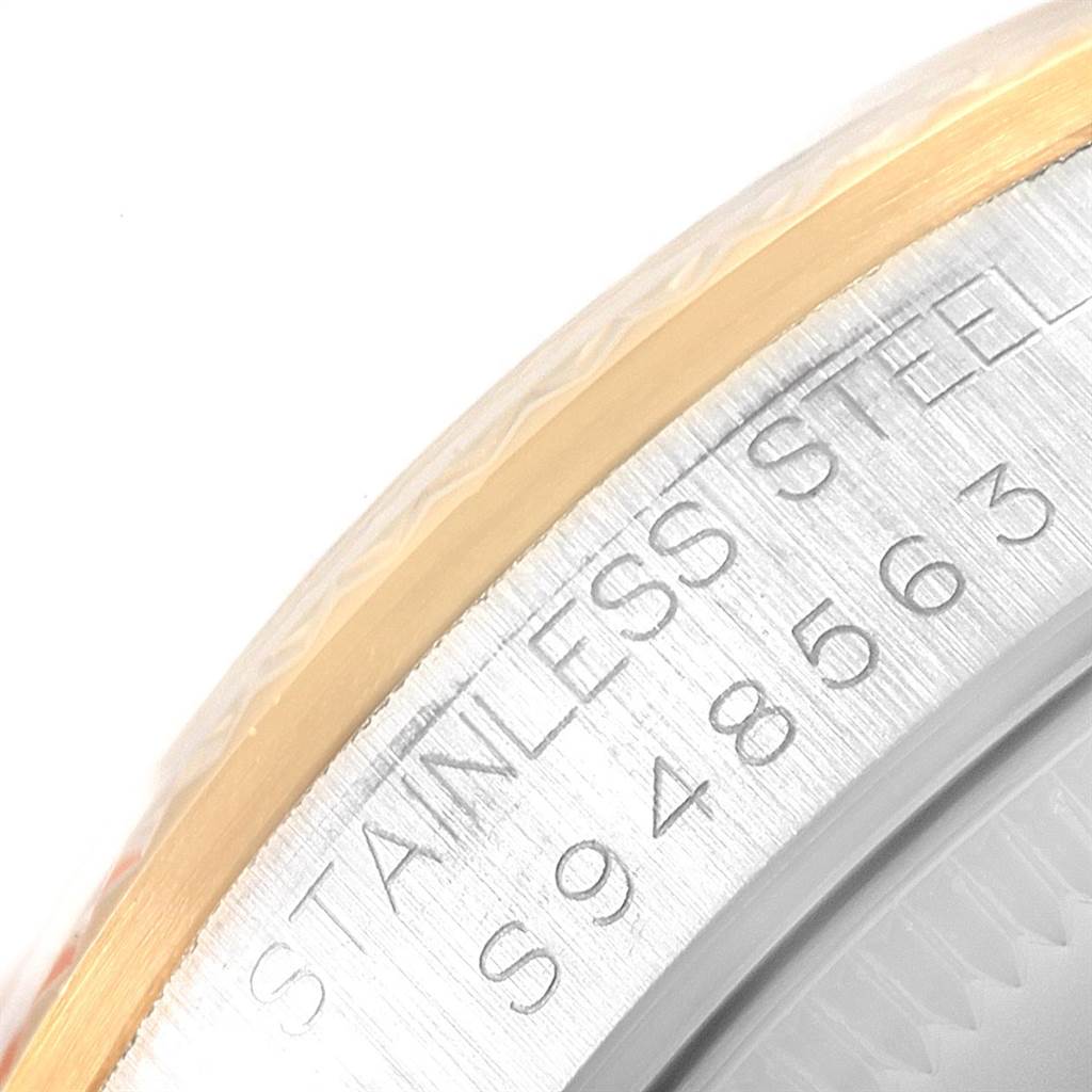 This image shows a close-up of the stainless steel and gold edge of a Mid-Size Rolex watch case, including part of its serial number.