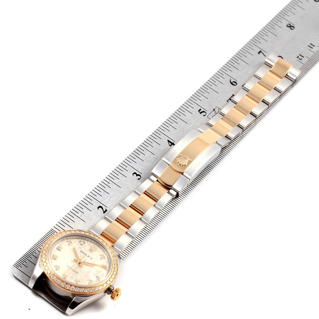 The Rolex Mid-Size 178383 Women's Steel and Gold (two tone) Silver Dial 178383 Women's Steel and Gold (two tone) Silver Dial watch is shown laying flat with the dial, bezel, bracelet, and clasp visible, next to a ruler for measurement.