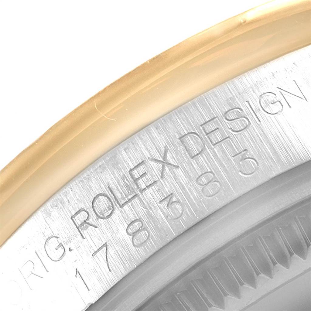 Close-up of a Rolex Mid-Size 178383 Women's Steel and Gold (two tone) Silver Dial 178383 Women's Steel and Gold (two tone) Silver Dial model, showing the engraved "ROLEX DESIGN" and model number on the case side.