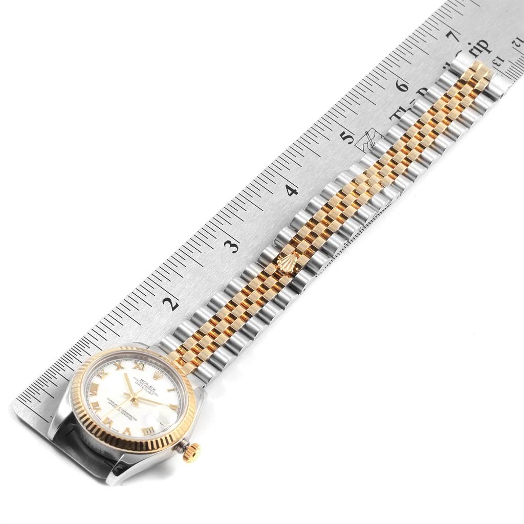 The image shows a Mid-Size Rolex watch laid flat next to a ruler, displaying the face, bezel, crown, and two-tone bracelet.