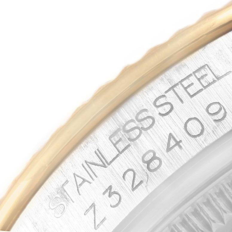 The image shows a close-up angle of the serial number and "STAINLESS STEEL" engraving on the bezel of a Mid-Size Rolex watch.