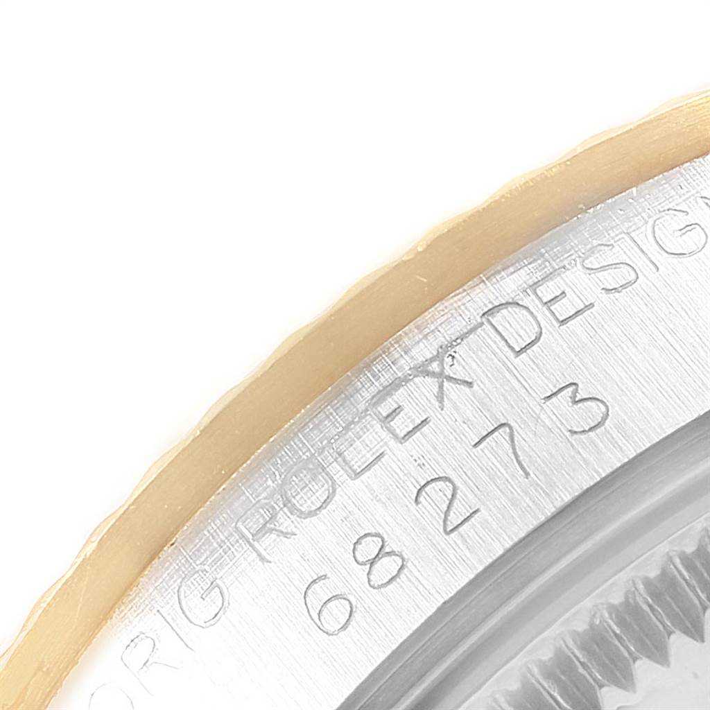 The image shows a close-up of the bezel and part of the casing with engraved text of a Rolex Mid-Size 68273 Women's Steel and Gold (two tone) White Dial 68273 Women's Steel and Gold (two tone) White Dial model watch.