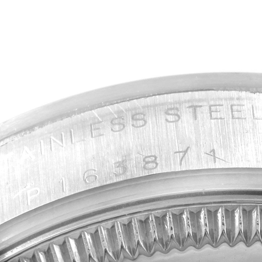 The image shows a close-up of the case back and bezel edge of a Mid-Size Rolex watch, highlighting engraved text and a serial number.