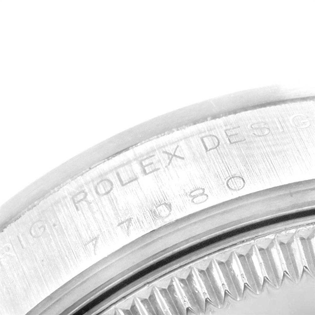 This image shows an angled close-up of the case back and edge of a Rolex Mid-Size 77080 Women's Stainless Steel Black Dial 77080 Women's Stainless Steel Black Dial model, highlighting the engraved text.