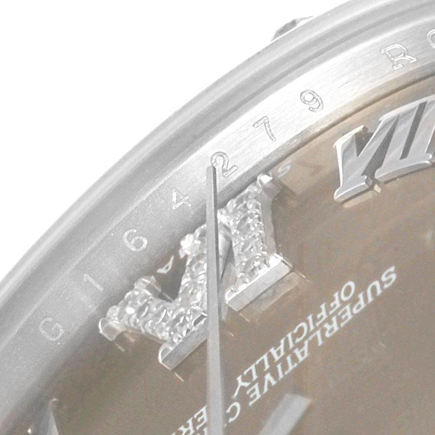 The image shows a close-up view of the dial and bezel of a Mid-Size Rolex watch, focusing on the Roman numeral '6' and surrounding details.