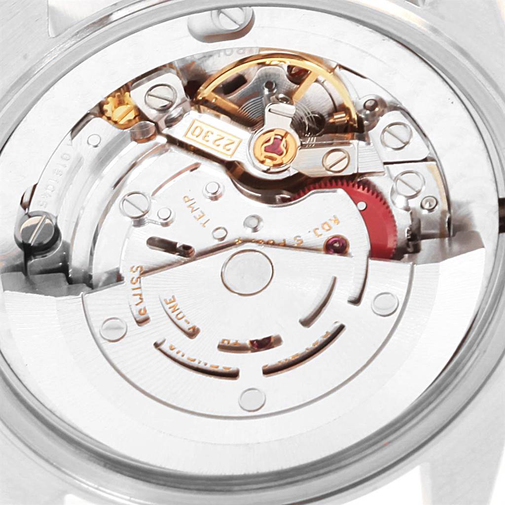 The image shows a close-up view of the inner mechanical movement of a Mid-Size Rolex watch.