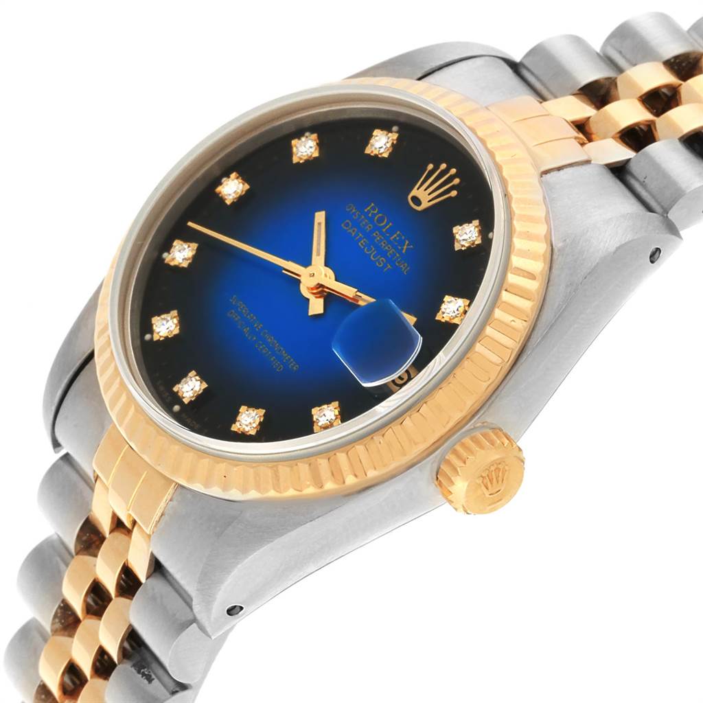 This image shows a side angle of a Rolex Mid-Size 68273 Women's Steel and Gold (two tone) Blue Dial 68273 Women's Steel and Gold (two tone) Blue Dial Datejust watch, featuring its dial, bezel, crown, and part of the bracelet.