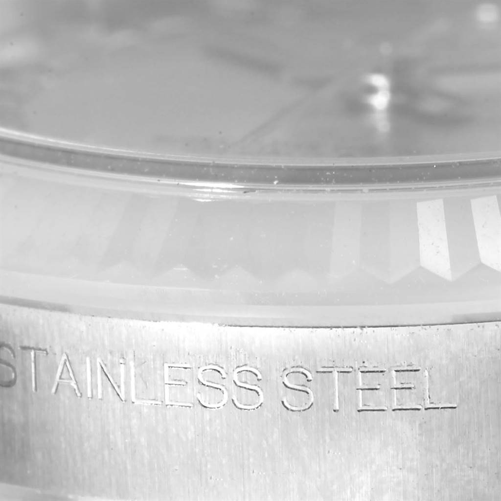 This image shows a close-up of the bezel and casing of a Mid-Size Rolex watch, highlighting the "STAINLESS STEEL" engraving.