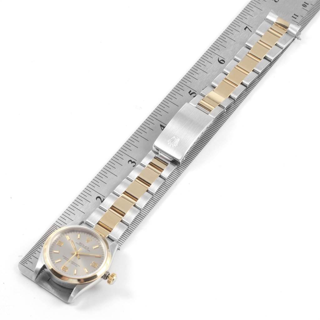 The Rolex Mid-Size 67483 Women's Steel and Gold (two tone) Grey Dial 67483 Women's Steel and Gold (two tone) Grey Dial watch is shown from an overhead angle, highlighting the face, crown, and two-tone bracelet with a clasp.
