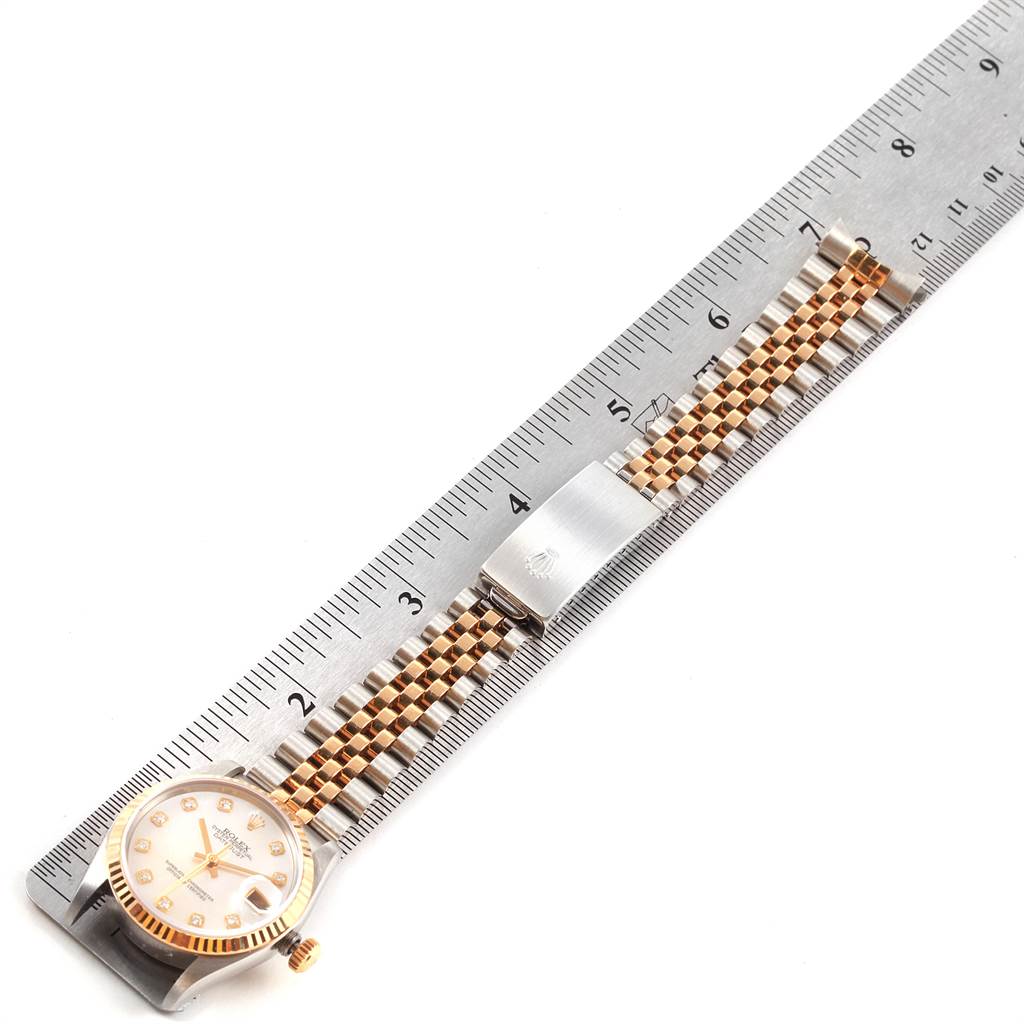 The image shows a Rolex Mid-Size 78273 Women's Steel and Gold (two tone) Mother of Pearl Dial 78273 Women's Steel and Gold (two tone) Mother of Pearl Dial watch laid flat next to a ruler, displaying its dial, bezel, and bracelet from a top-down angle.