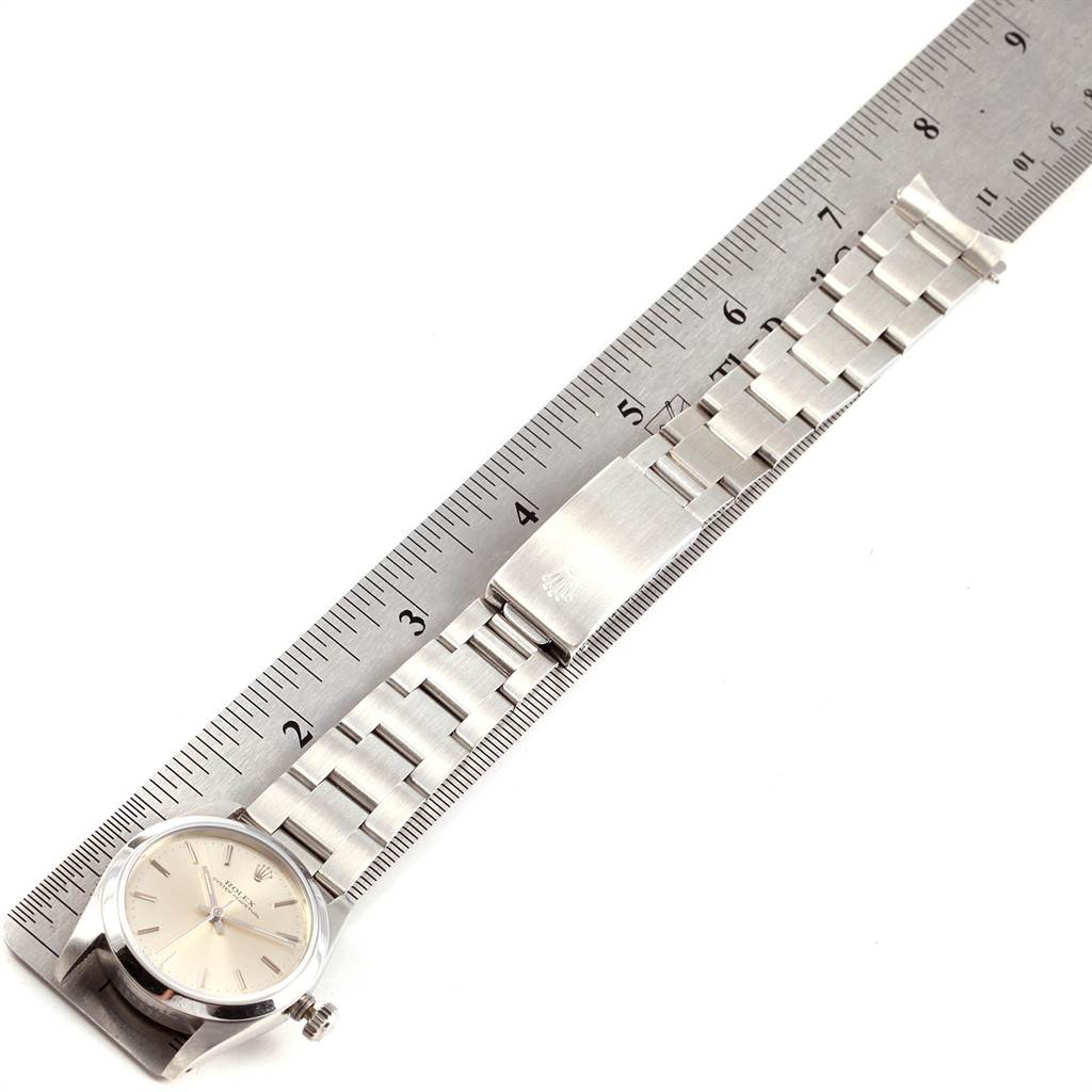 The image shows a Rolex Mid-Size 67480 Women's Stainless Steel Silver Dial 67480 Women's Stainless Steel Silver Dial watch and its bracelet, placed against a ruler, highlighting the case, dial, and clasp.