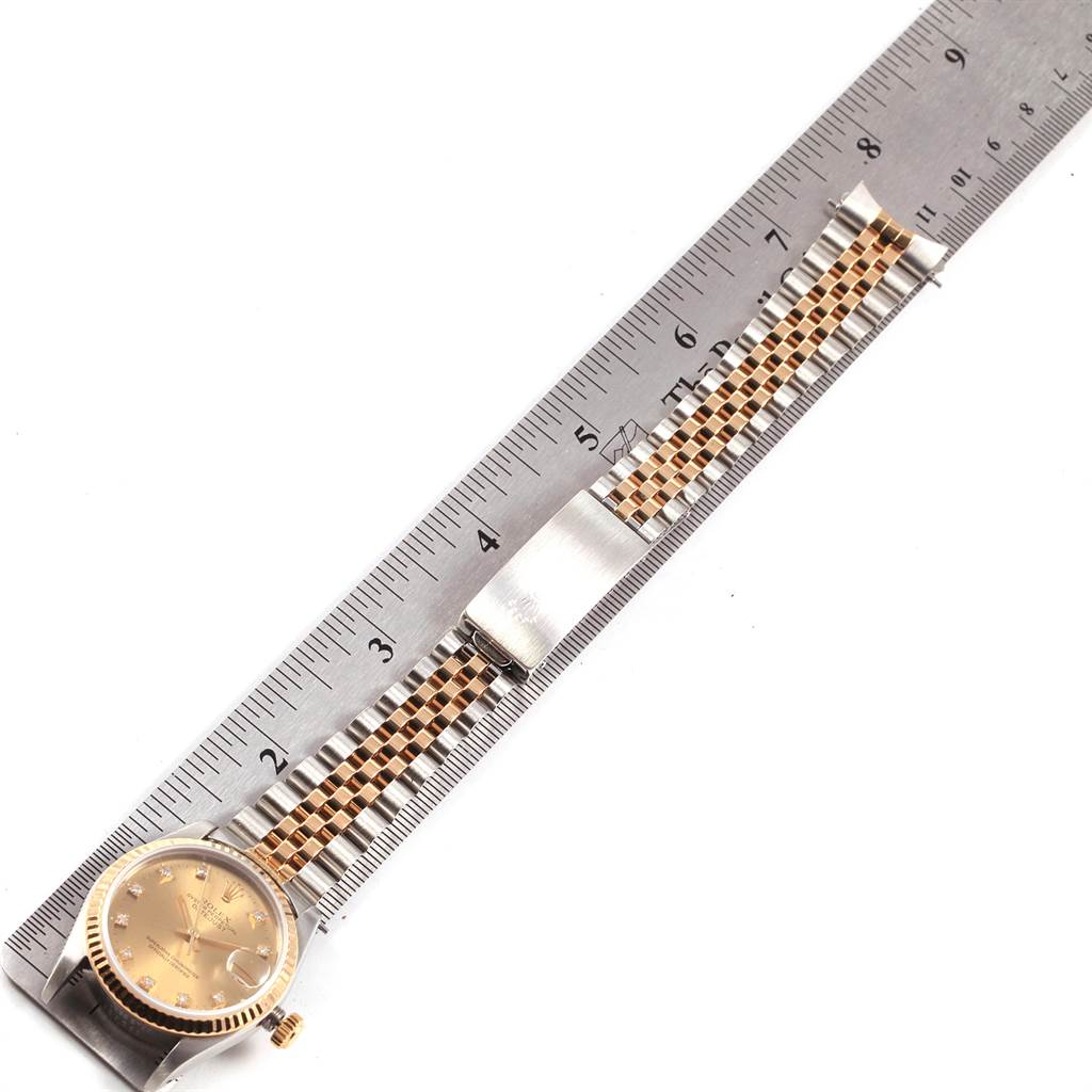 The Rolex Mid-Size 68273 Women's Steel and Gold (two tone) Champagne Dial 68273 Women's Steel and Gold (two tone) Champagne Dial watch is shown flat, laid on a ruler, displaying the face, bezel, and a two-tone bracelet.