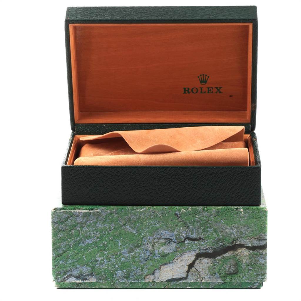 This image shows an open Rolex Mid-Size 77014 Women's Stainless Steel Silver Dial 77014 Women's Stainless Steel Silver Dial watch box with a green exterior and a wooden interior.