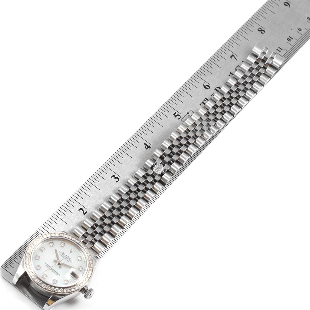 The image shows a Rolex Mid-Size 178384 Women's Stainless Steel Mother of Pearl Dial 178384 Women's Stainless Steel Mother of Pearl Dial watch laid flat with a ruler, highlighting its dial and bracelet.