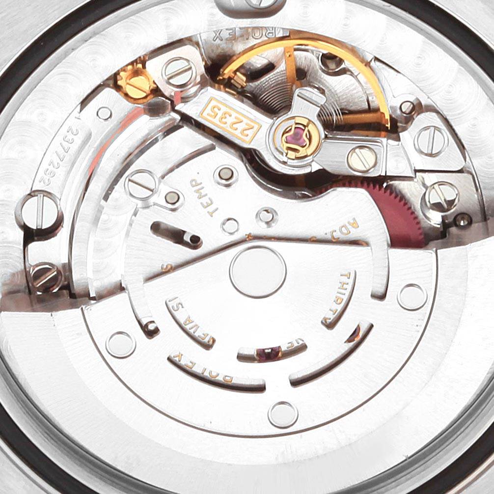 The image shows a close-up view of the movement mechanism parts inside a Mid-Size Rolex watch.