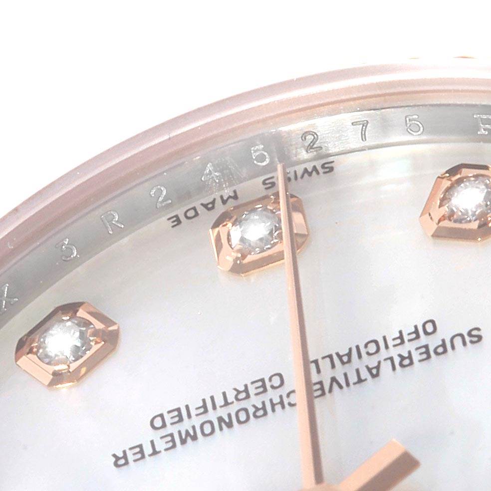 The image shows a close-up angle of the dial and bezel of a Mid-Size Rolex watch, highlighting its markers and inscriptions.