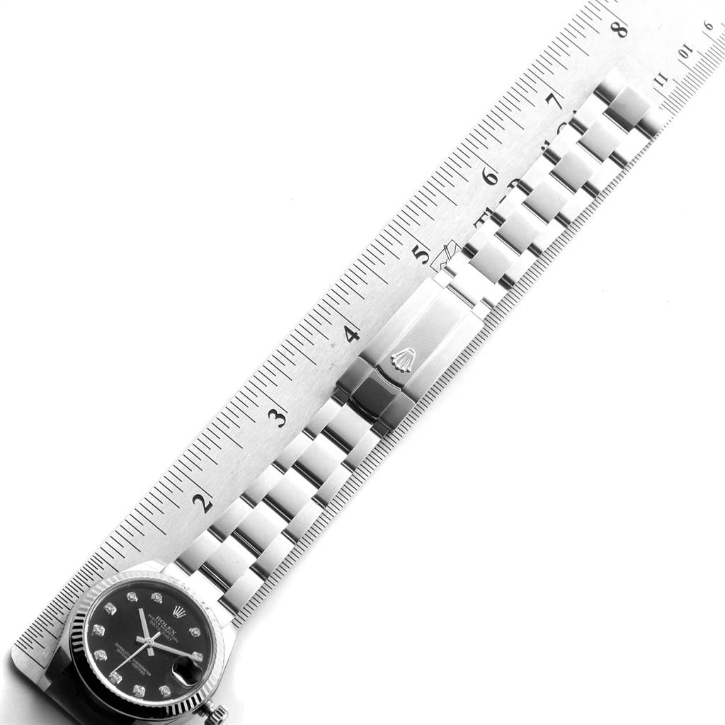 The image shows a Mid-Size Rolex watch and its metal bracelet aligned with a ruler for measurement.