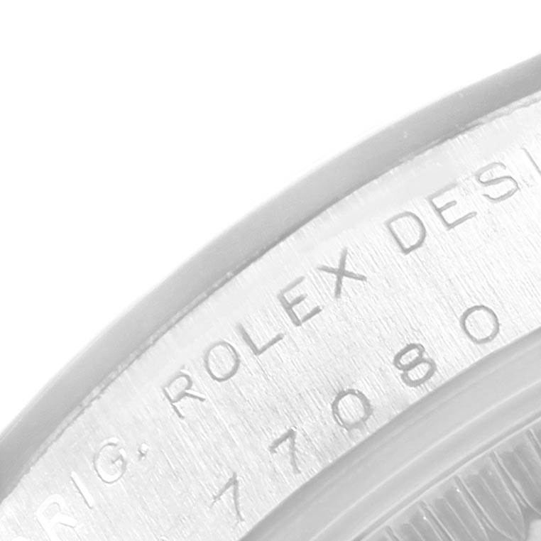 This image shows an angled close-up of the engraved case and bezel of a Rolex Mid-Size 77080 Women's Stainless Steel Pink Dial 77080 Women's Stainless Steel Pink Dial model watch.