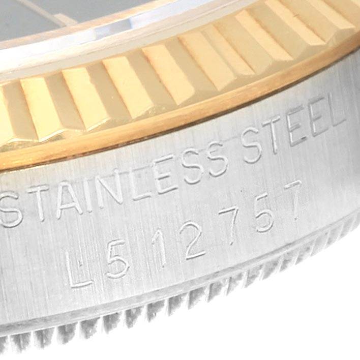 This close-up image shows the side view of the bezel and serial number engraving on a Mid-Size Rolex watch.