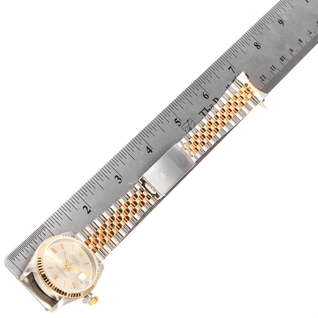 This image shows a Rolex Mid-Size 68273 Women's Steel and Gold (two tone) Silver Dial 68273 Women's Steel and Gold (two tone) Silver Dial watch laid flat against a ruler, displaying the entire watch and bracelet with clasp.