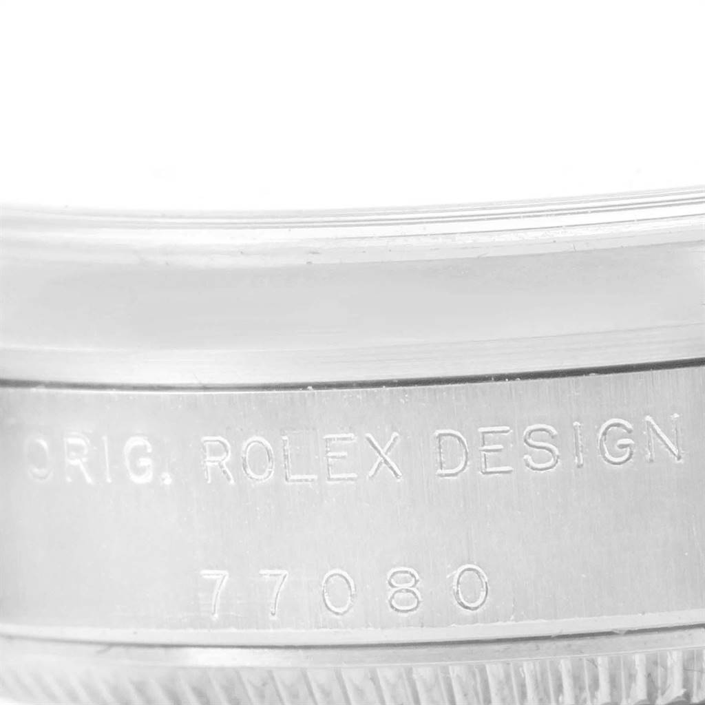 The image shows a close-up of the side of a Rolex Mid-Size 77080 Women's Stainless Steel Pink Dial 77080 Women's Stainless Steel Pink Dial watch, featuring the serial number and engraving "ORIG. ROLEX DESIGN 77080".