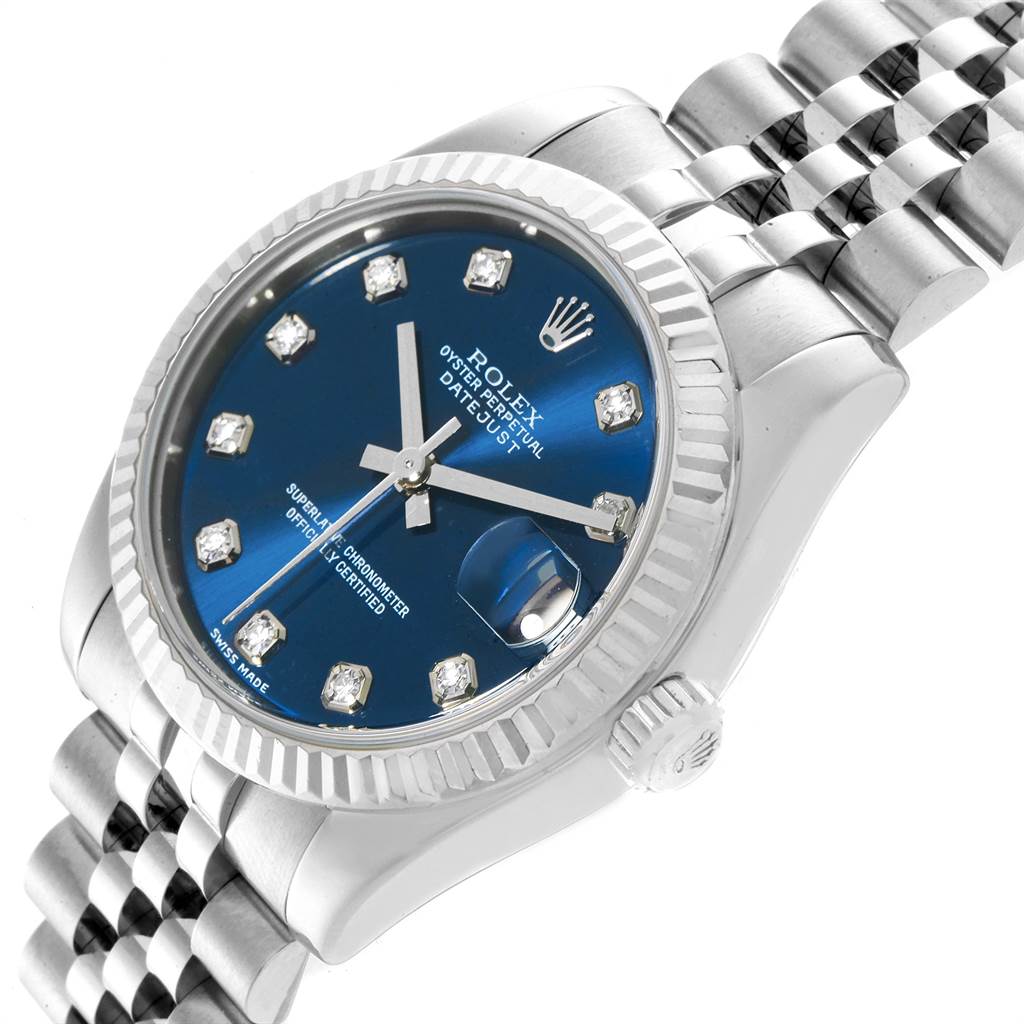 The image shows a close-up angle of the Rolex Datejust Mid-Size watch, featuring its blue dial, bezel, crown, and part of the bracelet.