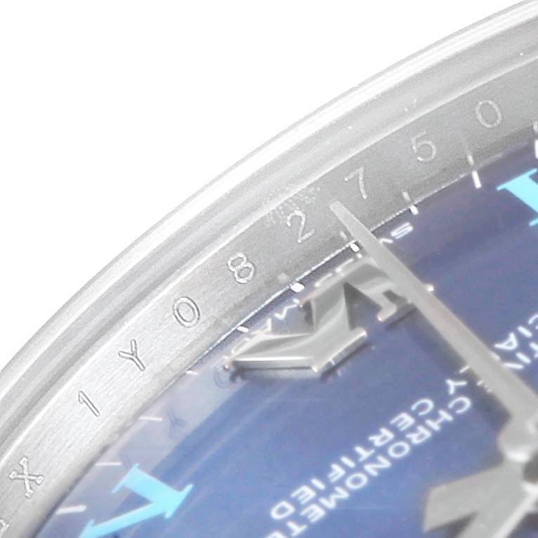 This close-up angle of the Rolex Mid-Size 177200 Women's Stainless Steel Blue Dial 177200 Women's Stainless Steel Blue Dial model watch shows part of the dial, hands, and chapter ring with engraved numbers.