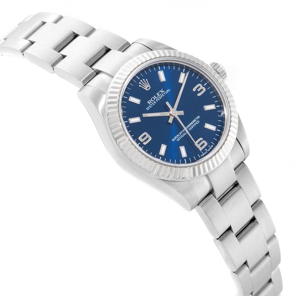 The Mid-Size Rolex watch is shown at an angled view, displaying its bracelet, blue dial, and fluted bezel.