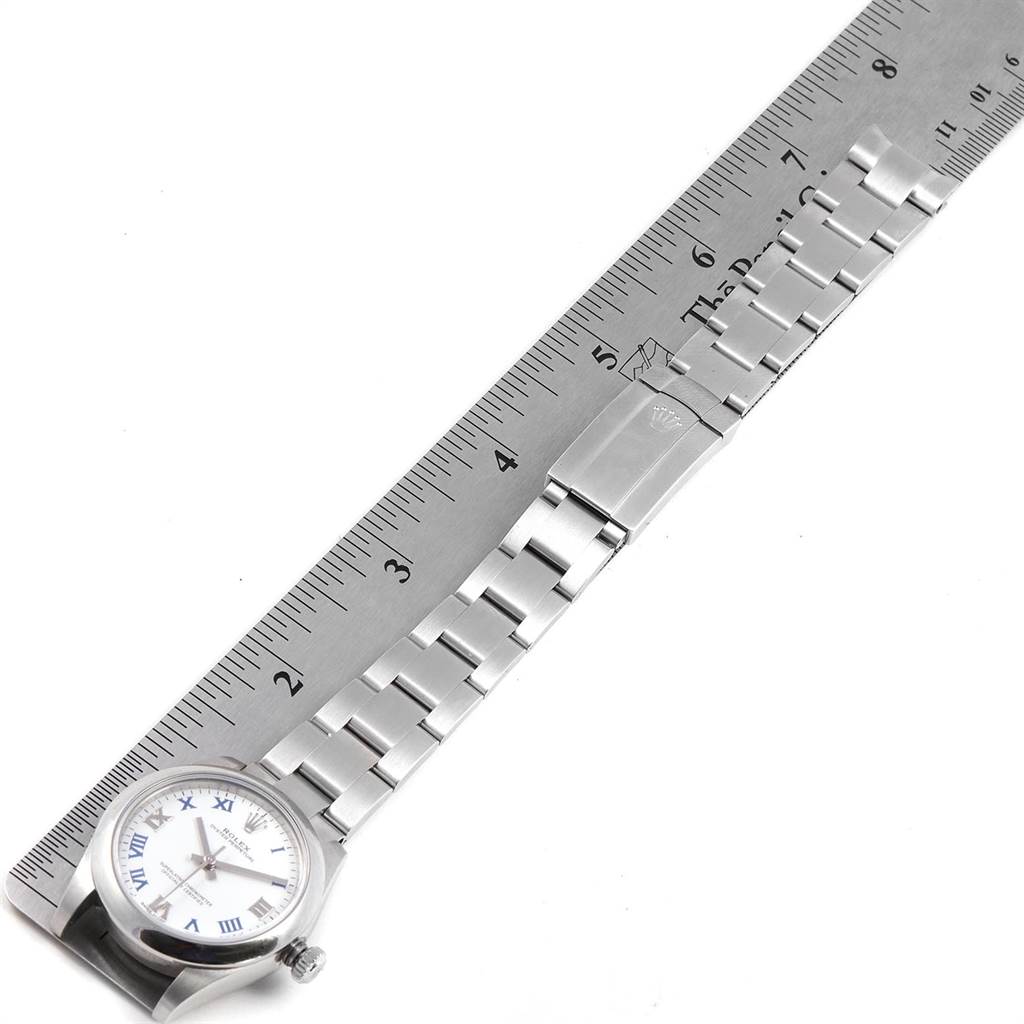 The image shows a Rolex Mid-Size 177200 Women's Stainless Steel White Dial 177200 Women's Stainless Steel White Dial watch from an angled top view, focusing on its face, bracelet, and clasp alongside a ruler for scale.