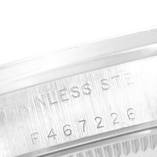 This image features a close-up of the side of a Rolex Mid-Size 77080 Women's Stainless Steel Black Dial 77080 Women's Stainless Steel Black Dial model watch, highlighting the engraved serial number and "STAINLESS STEEL" text.