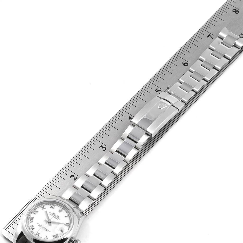 The image shows a top view of a Mid-Size Rolex watch with its bracelet laid out next to a ruler for size reference.