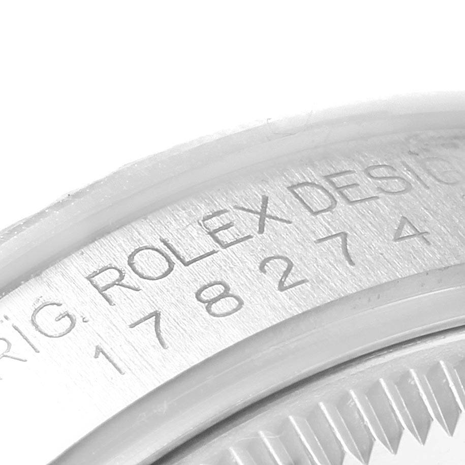 This is a close-up of the case back of a Rolex Mid-Size 178274 Women's Stainless Steel Silver Dial 178274 Women's Stainless Steel Silver Dial model, showing part of the engraving and the fluted edge.