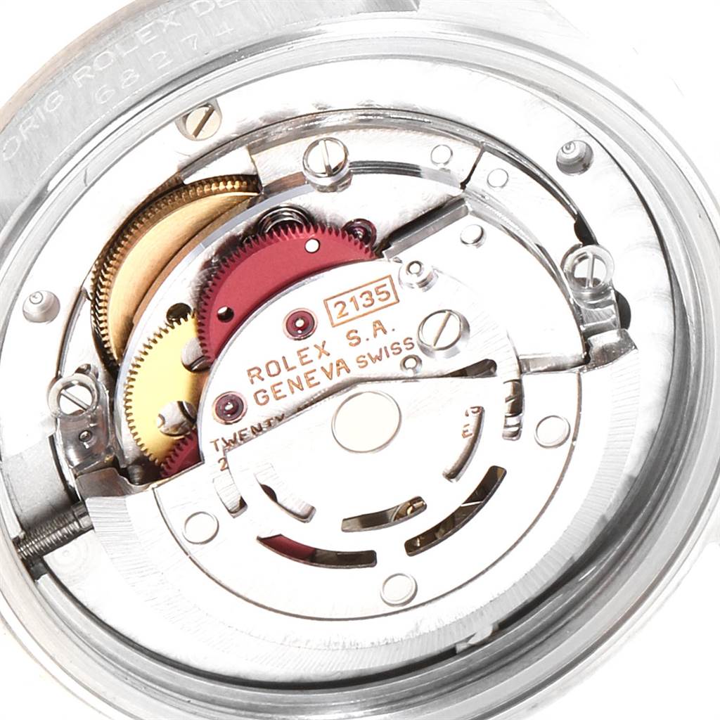 This image shows the internal movement mechanism of a Mid-Size Rolex watch, including gears and the rotor.