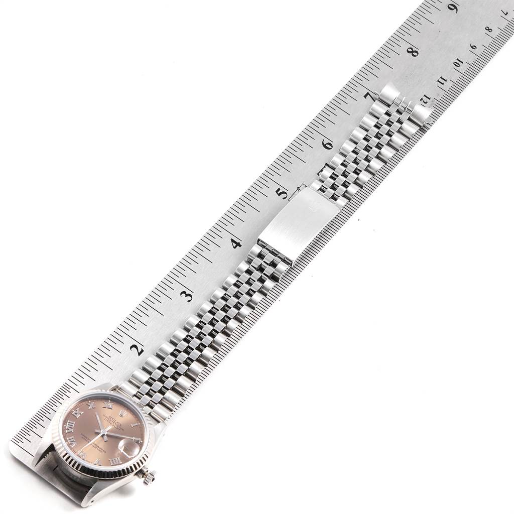 The Rolex Mid-Size 68274 Women's Stainless Steel Pink Dial 68274 Women's Stainless Steel Pink Dial model watch is shown at an angled top-down view, alongside a metal ruler for measurement.