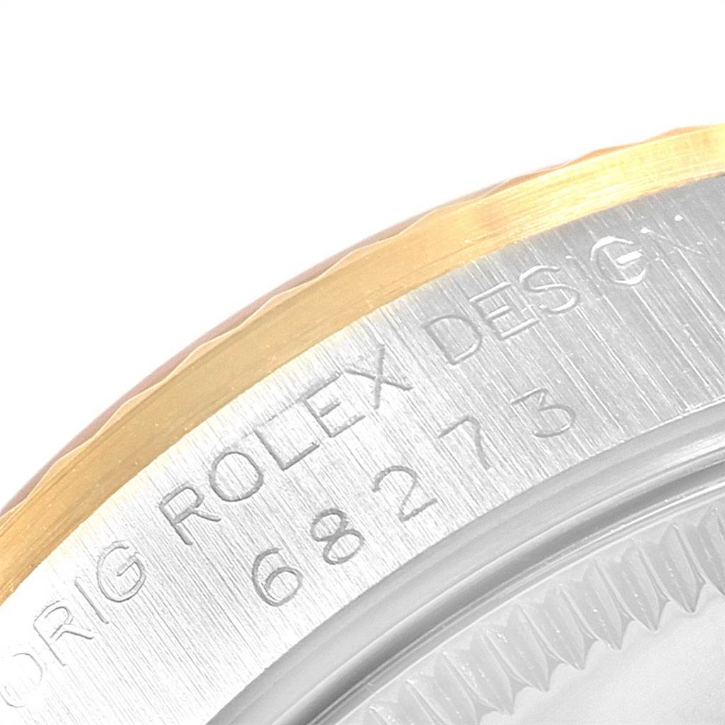 The image shows a close-up of the case back and bezel edge of a mid-size Rolex watch, including engraved text and reference number.