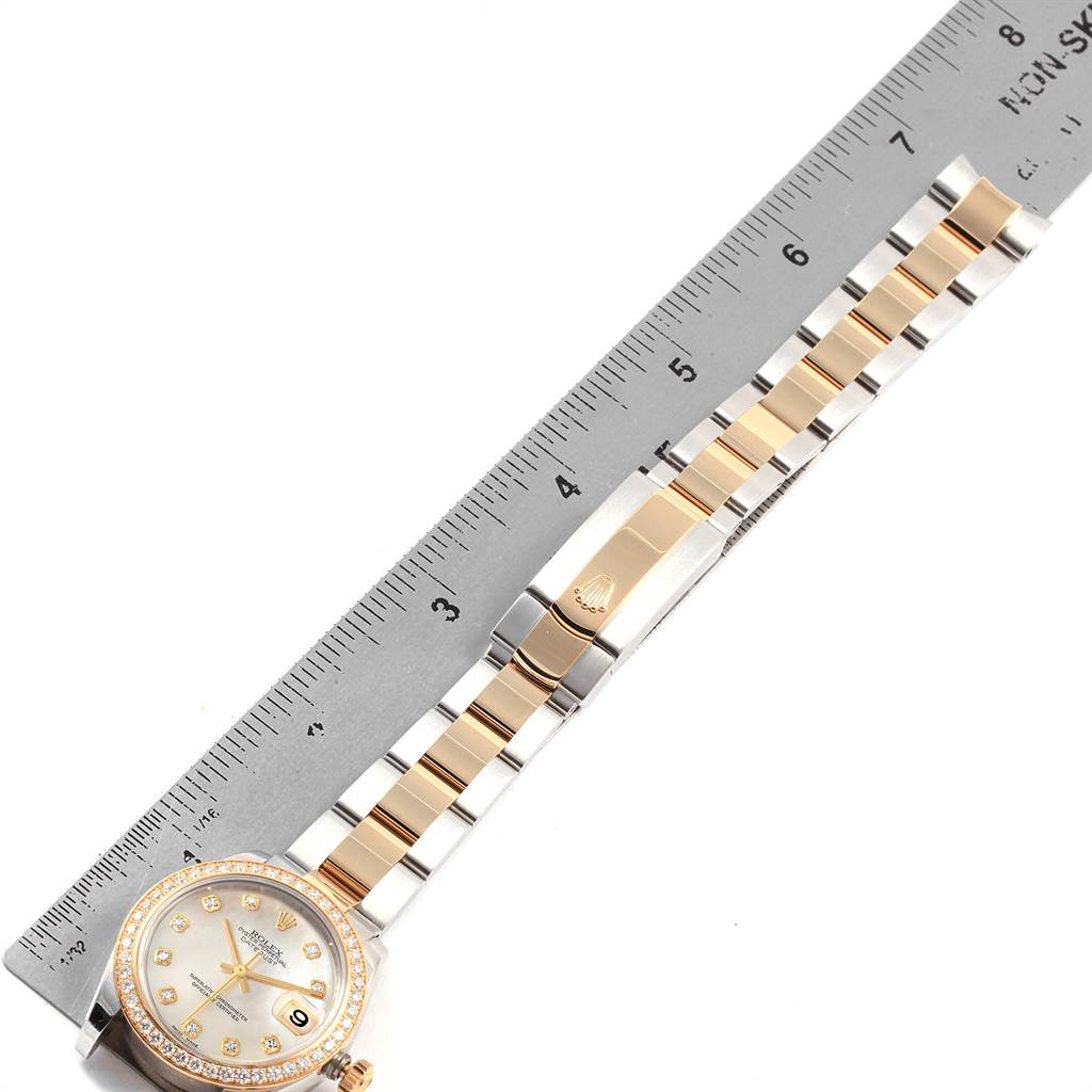 The image shows a Rolex Mid-Size 178383 Women's Steel and Gold (two tone) Mother of Pearl Dial 178383 Women's Steel and Gold (two tone) Mother of Pearl Dial watch laid flat, displaying the face, bezel, and bracelet with a ruler beside it for scale.