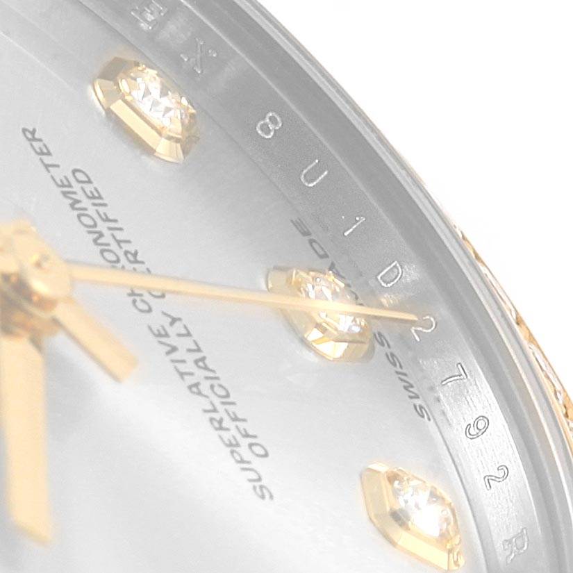 This close-up image shows the dial, hands, and diamond hour markers of a Mid-Size Rolex watch.